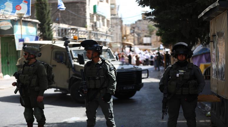 جنود إسرائيليون يفرضون قيوداً على حركة المواطنين خلال جولة للمستعرين في البلدة القديمة بمدينة الخليل